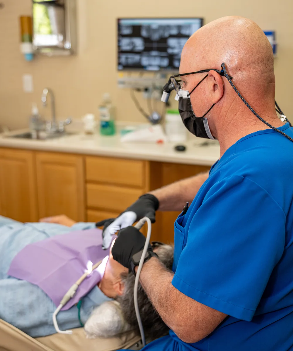 A dentist treating a patient in the practice's operatory